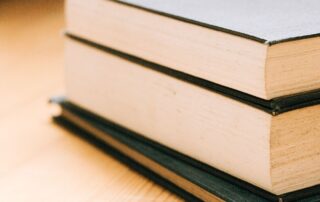 Stack of cloth covered hardcover books showing the text block edges and case boards