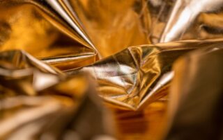 Close-up of crinkled gold metallic paper with a reflective, shimmering surface